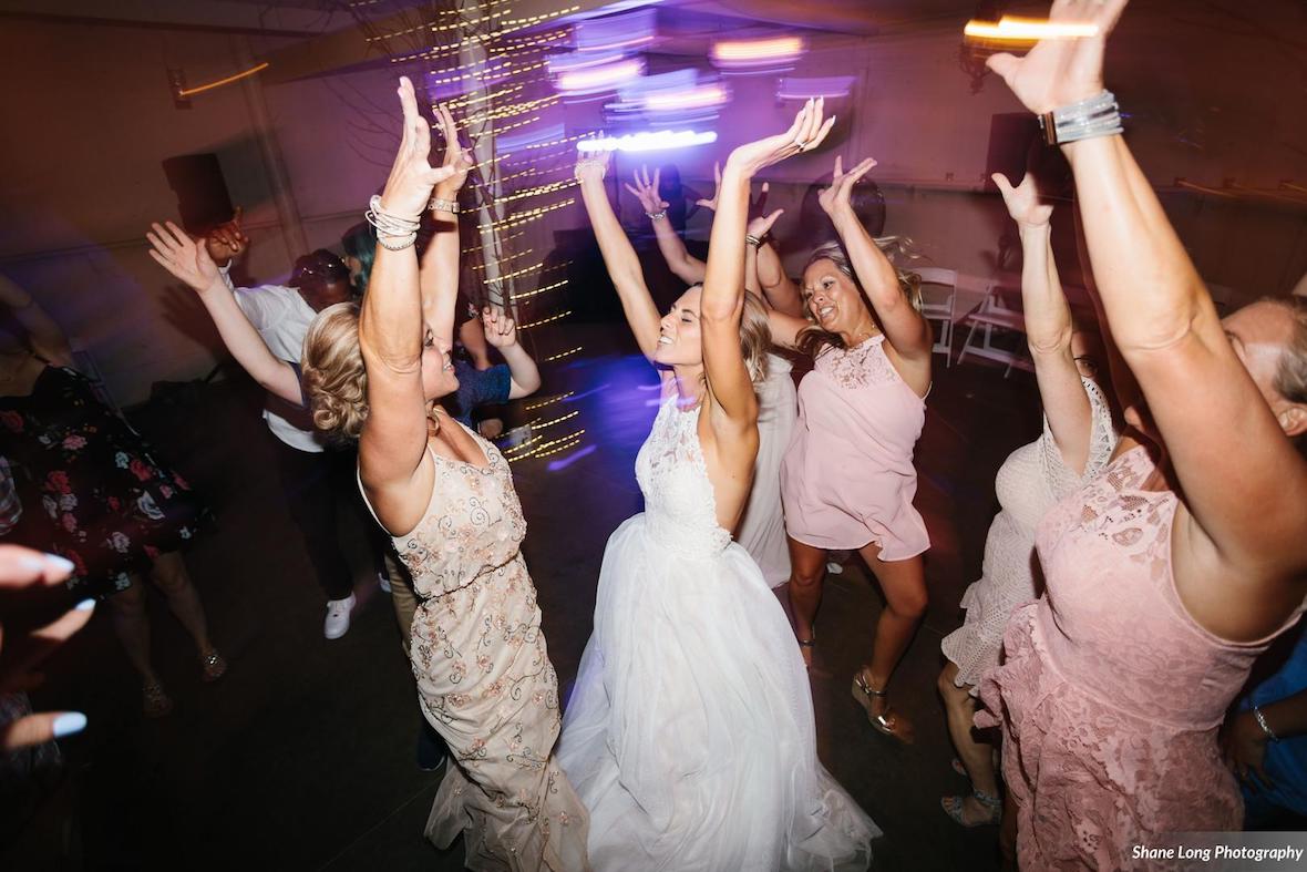 bride_dancing_with_arms_up_with_bridesmaids