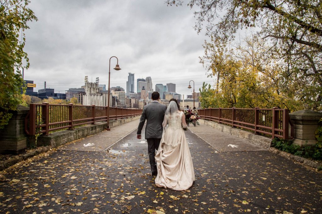bride and groom on stone arch bridge