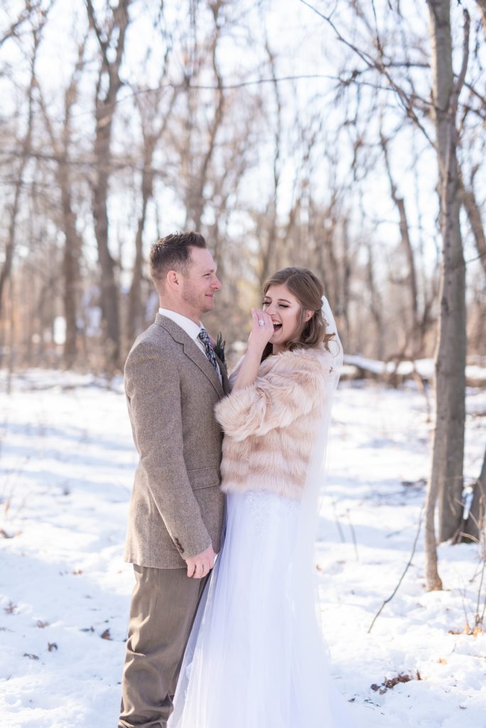 bride and groom laughing in the snow