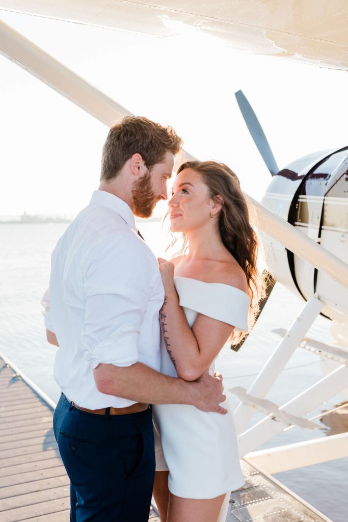 bride and groom next to small plane