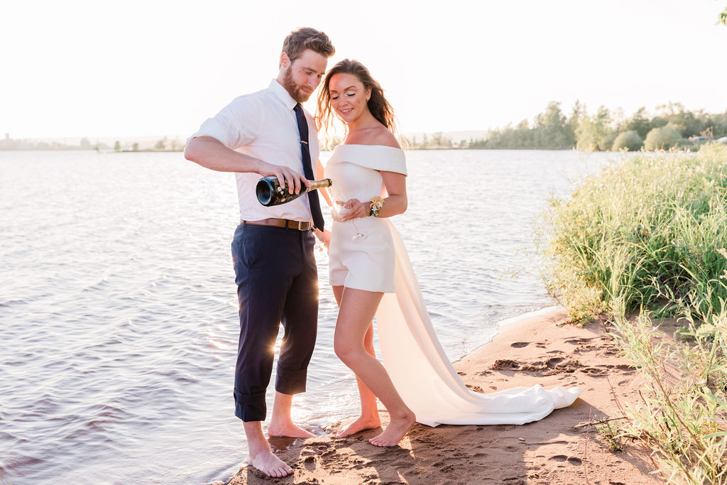 groom pouring bride a glass of champagne