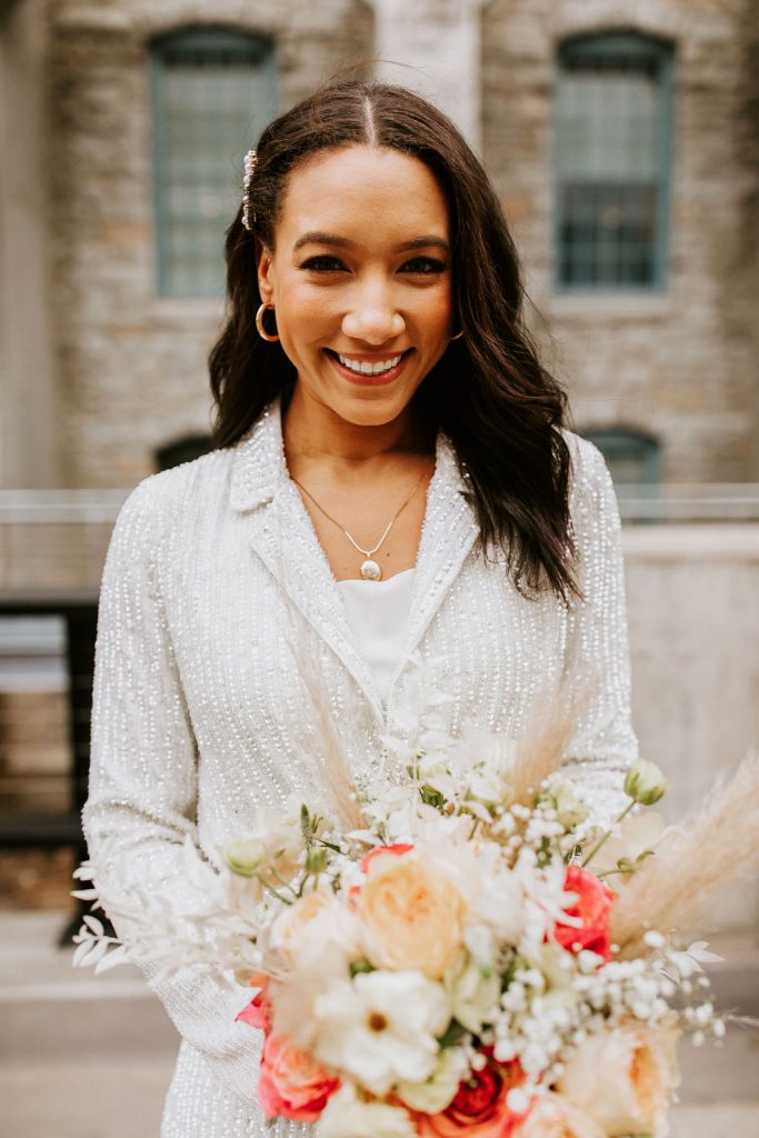 bride in sequin beaded blazer holding bouquet 