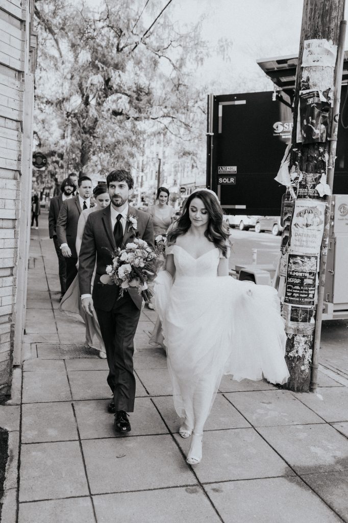 black and white image of bridal party walking 