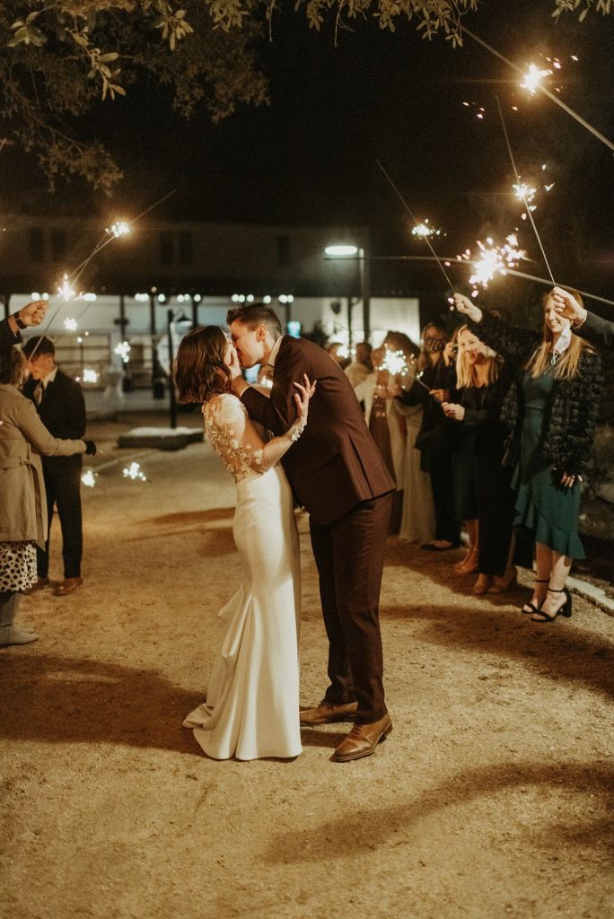 bride and groom kissing during sparkler exit