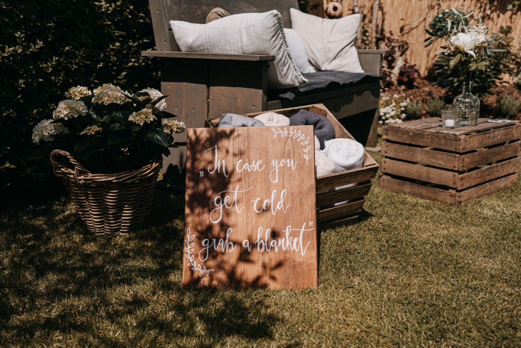 Outdoor wedding with a basket of blankets for guests