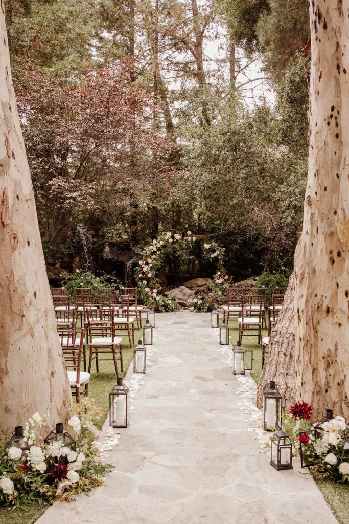 Outdoor ceremony with lanterns along the aisle 