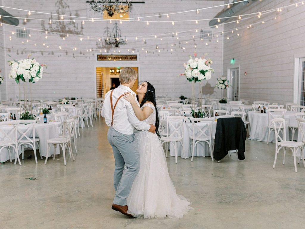 bride and groom dancing at romantic barn wedding in Texas