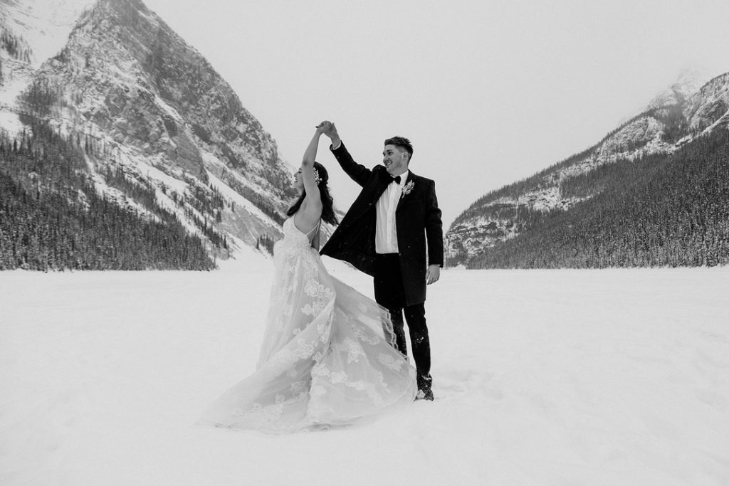 A couple dances in the snow at their winter wedding