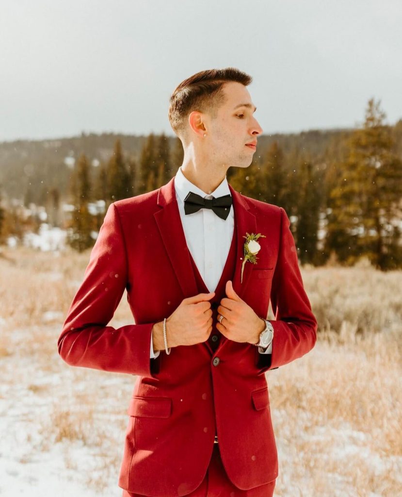 A groom in a red tuxedo