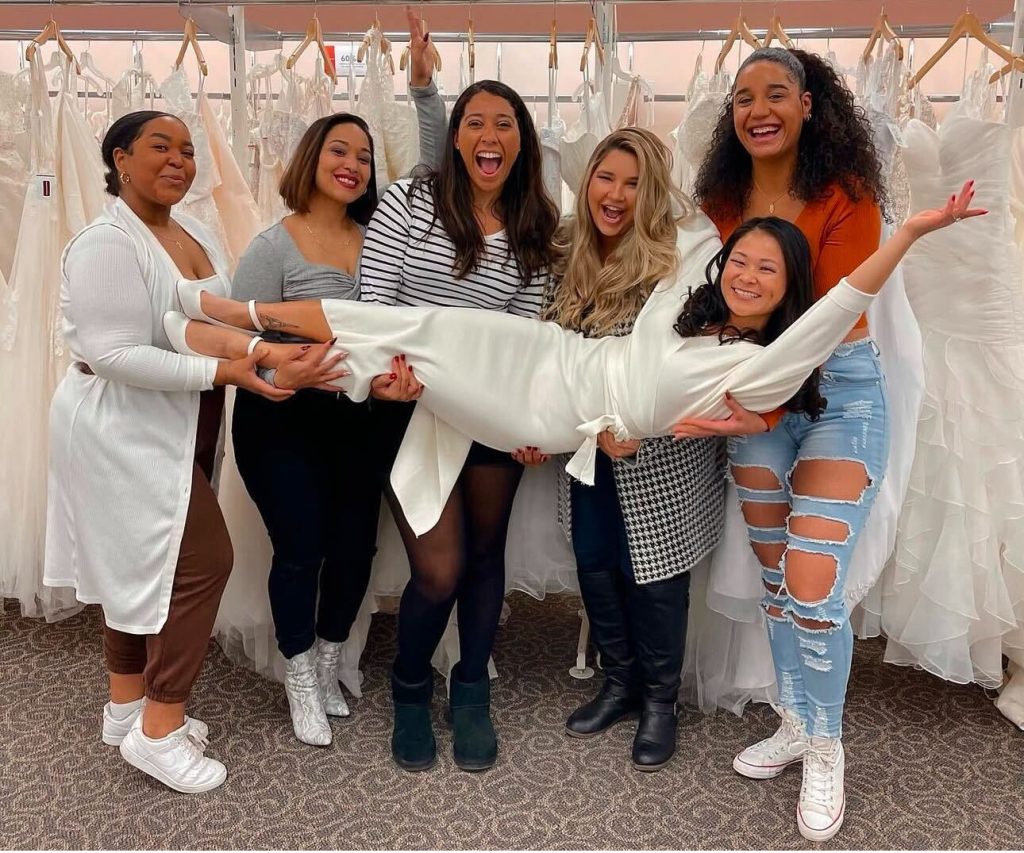 Bridesmaids holding up a bride at her David's Bridal wedding dress appointment